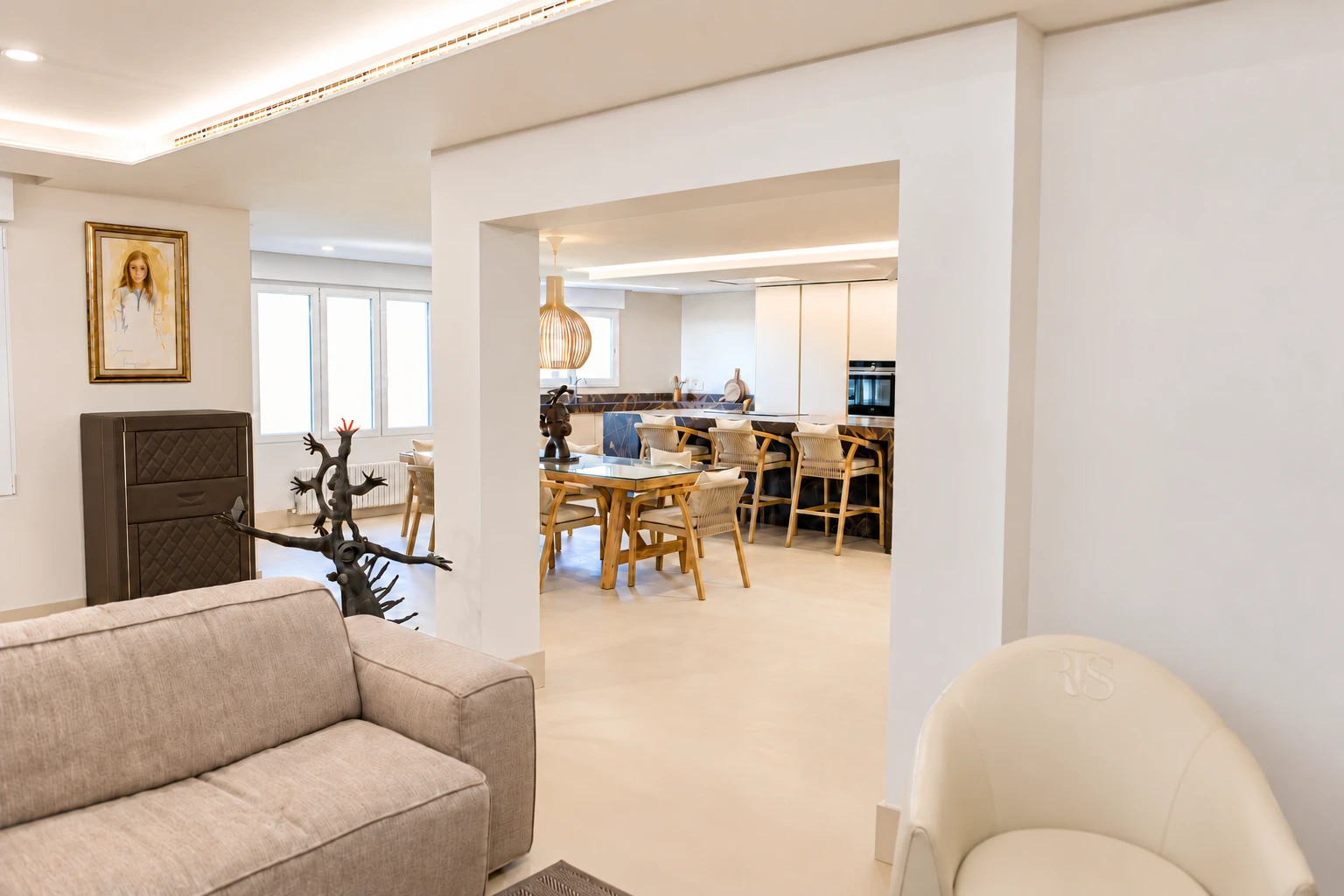 Salón con sofá y vistas al comedor y la cocina.